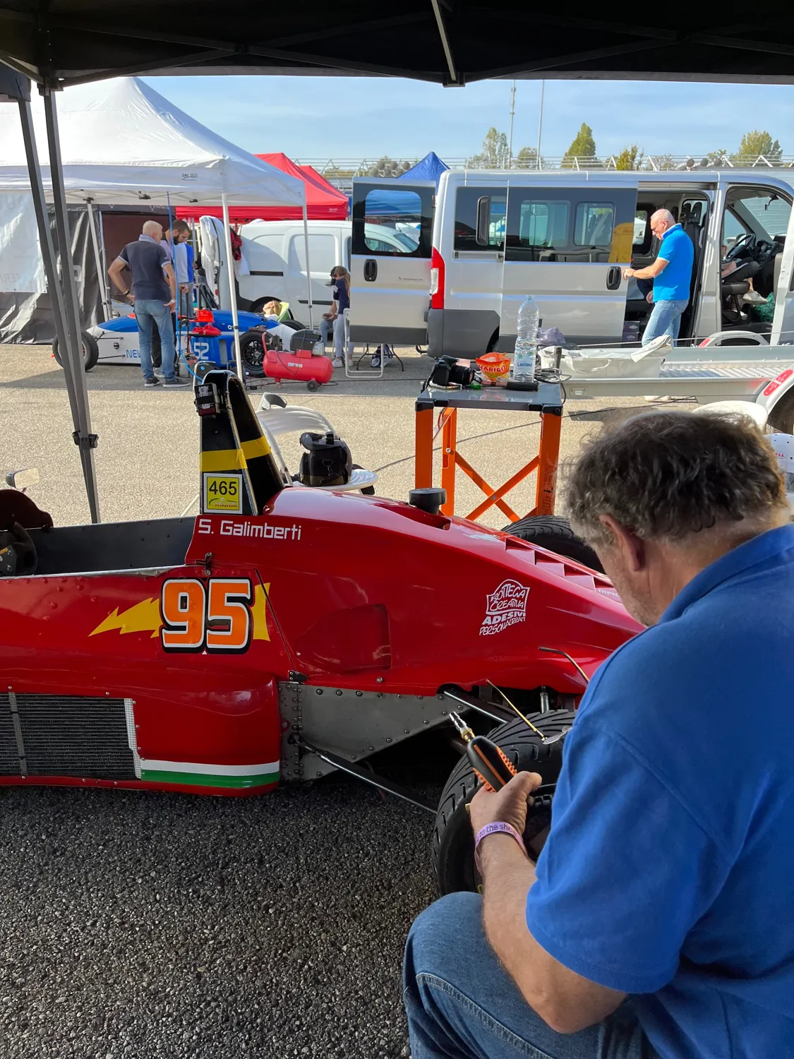 Un meccanico al lavoro sulla gomma della monoposto ai box