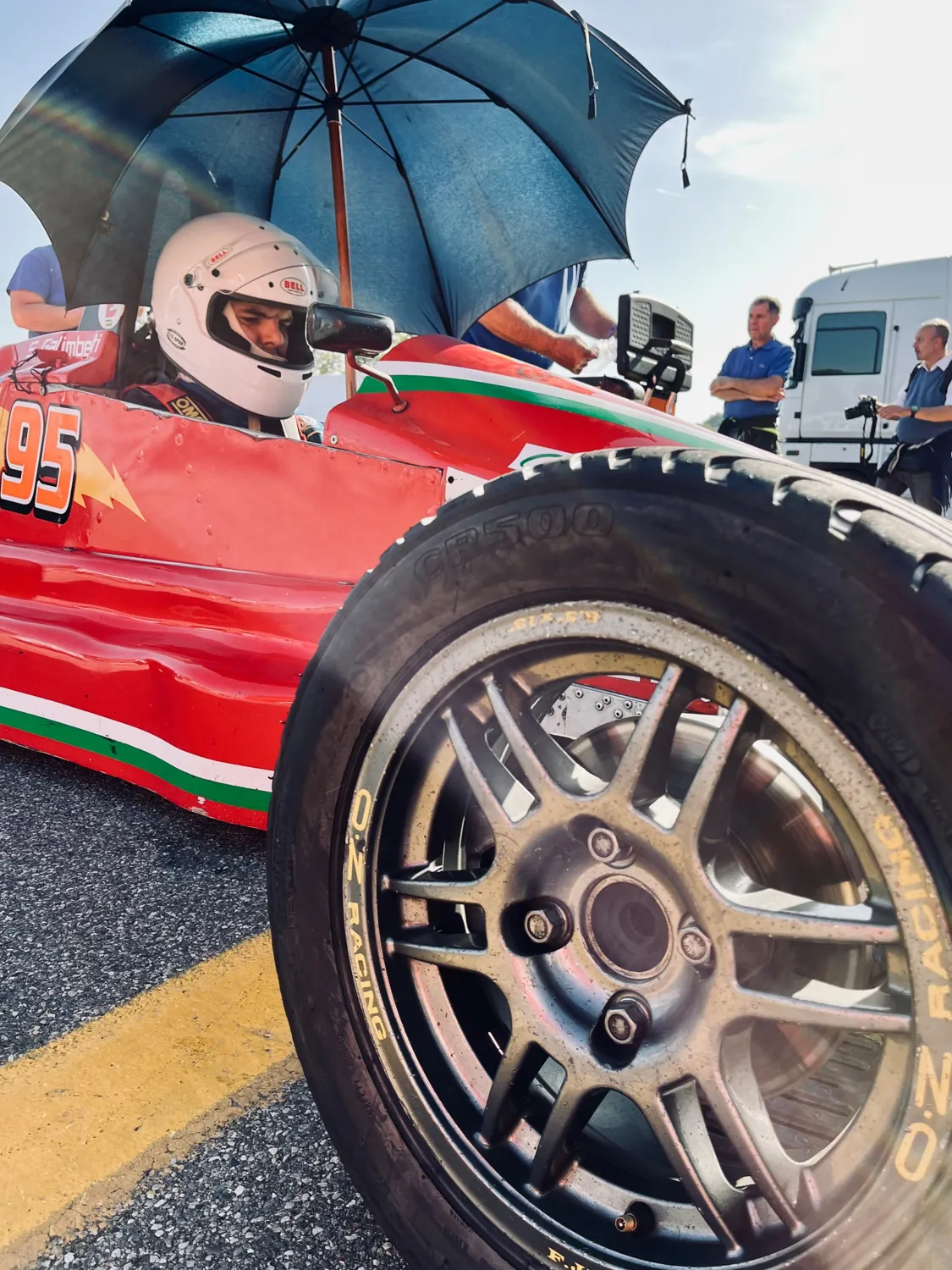 Stefano Galimberti nell'abitacolo della monoposto sotto un ombrello ai box