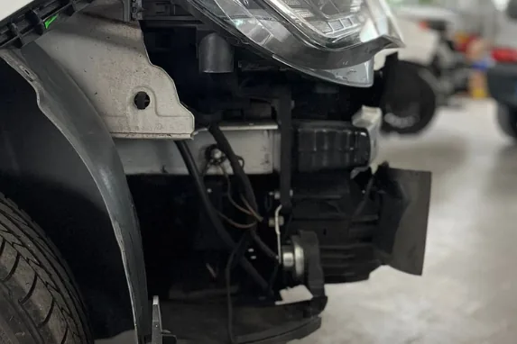 Vano motore e gruppo frontale di un'auto in revisione